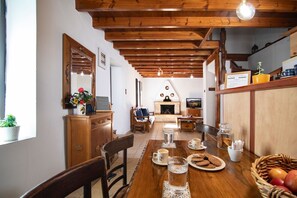 A cozy dining area with wooden furniture, a fireplace, and a dining table set for a meal.