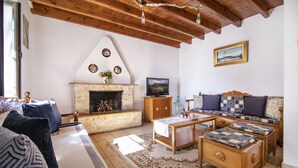 A cozy living room with a fireplace, a sofa set, and a coffee table. - Mikros Paradisos Pelion (Άγιος Βλάσιος)