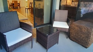 Una habitación con muebles de mimbre, incluyendo dos sillones y una mesita.