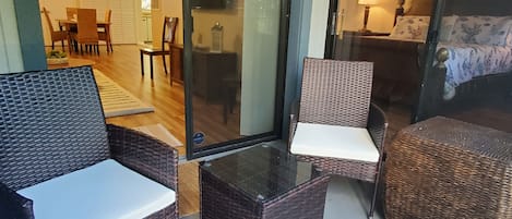 Una habitación con muebles de mimbre, incluyendo dos sillones y una mesita.