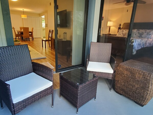 Una habitación con muebles de mimbre, incluyendo dos sillones y una mesita.