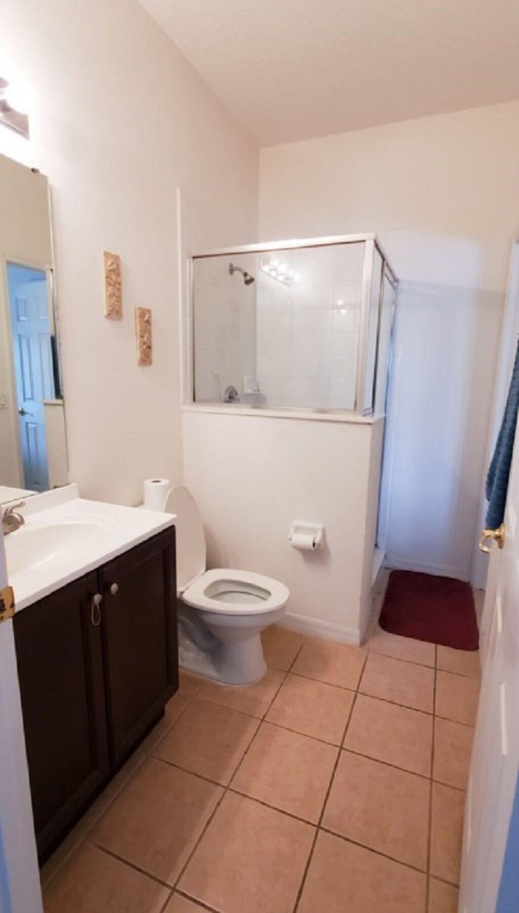 A bathroom with a toilet, sink, and shower.