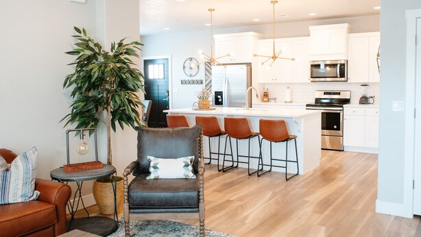 A modern kitchen with white cabinets, stainless steel appliances, and a central island with bar stools. - Adventure Awaits in Southern Utah | Pool + Resort Style Amenities | Come Adventure with Family! (Washington)