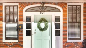 A house with a light green door, number 1531, a brick facade, and a wreath on the door. - Modern Midtown Retreat (Montgomery)