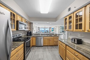 Una cocina moderna con armarios de madera, electrodomésticos de acero inoxidable y una isla grande.