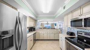 A modern kitchen with stainless steel appliances, a large island, and a view to the outside. - Shore Enuff - Destin Gulfgate 0601! (Destin)