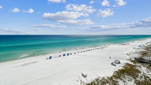 A wide sandy beach with clear turquoise water and a few people. - Where every hour is Happy Hour - Destin Gulfgate 0602! (Destin)
