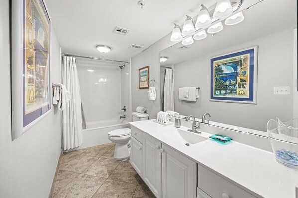 A bathroom with a shower, toilet, and sink.