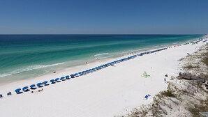 Una playa de arena blanca bajo un cielo azul claro.