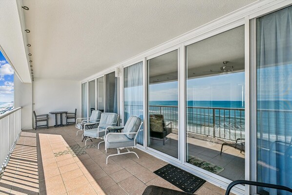 Varanda com vista para o oceano, equipada com cadeiras e uma mesa.