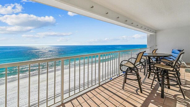 A balcony with a view of the ocean, a table with chairs, and a railing. - Off the Hook - Destin Gulfgate 0802! (Destin)