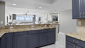 A modern kitchen with dark cabinets, granite countertops, and a large island. - Beachy Keen - Destin Gulfgate 0805! (Destin)