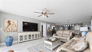A spacious living room with a beige sofa, a coffee table, and a television. There is a ceiling fan, a large vase, and a painting on the wall. - Beachy Keen - Destin Gulfgate 0805! (Destin)