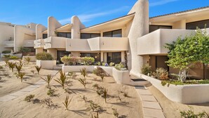 Un hôtel doté d’un jardin de style désertique, de nombreux balcons et offrant une vue sur un ciel bleu azur.