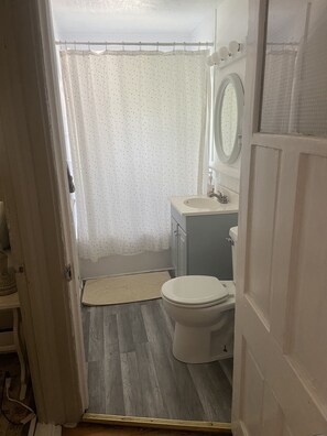 Kylpyhuone, jossa on wc, pesuallas ja peili.