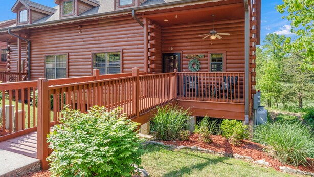 A log cabin with a covered porch, a front door, and a number '324' sign. - Spacious, Luxury 2BR+Loft Cabin with Fireplace & Balcony - Close to Entertainment! (Branson)