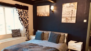 A bedroom with a bed, a bedside table, a lamp, and a window with curtains. - 3 Bedroom Country Retreat - Dogs Welcome (Appleby-in-Westmorland)