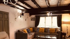 A cozy living room with a sofa set, a coffee table, and a chandelier. - 3 Bedroom Country Retreat - Dogs Welcome (Appleby-in-Westmorland)