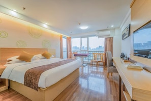 A hotel room with a large bed, a desk, a chair, and a view of the city. - Greentree Inn Yancheng Jiefang Road Express Hotel (Yancheng)