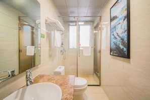 A modern bathroom with a glass-enclosed shower, a sink, and a toilet. - Greentree Inn Yancheng Jiefang Road Express Hotel (Yancheng)
