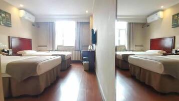 A hotel room with two beds, a desk, a chair, and a TV.
