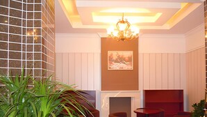 A modern lobby with a fireplace, seating area, and a large plant. - Greentree Inn Qinhuangdao Olympic Center Express (Qinhuangdao)