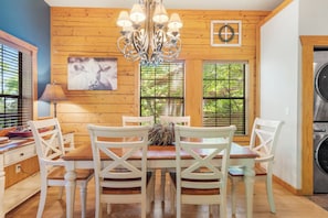 Enjoy meals in this dining area with a large chandelier and comfortable seating for four.