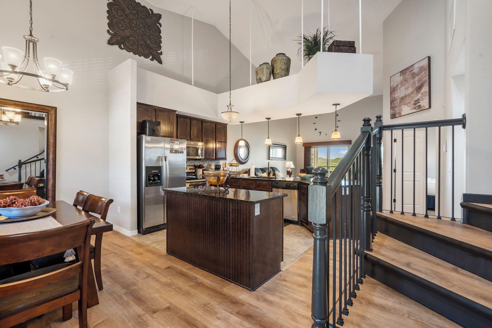 A spacious kitchen with a central island, wooden flooring, and modern appliances.