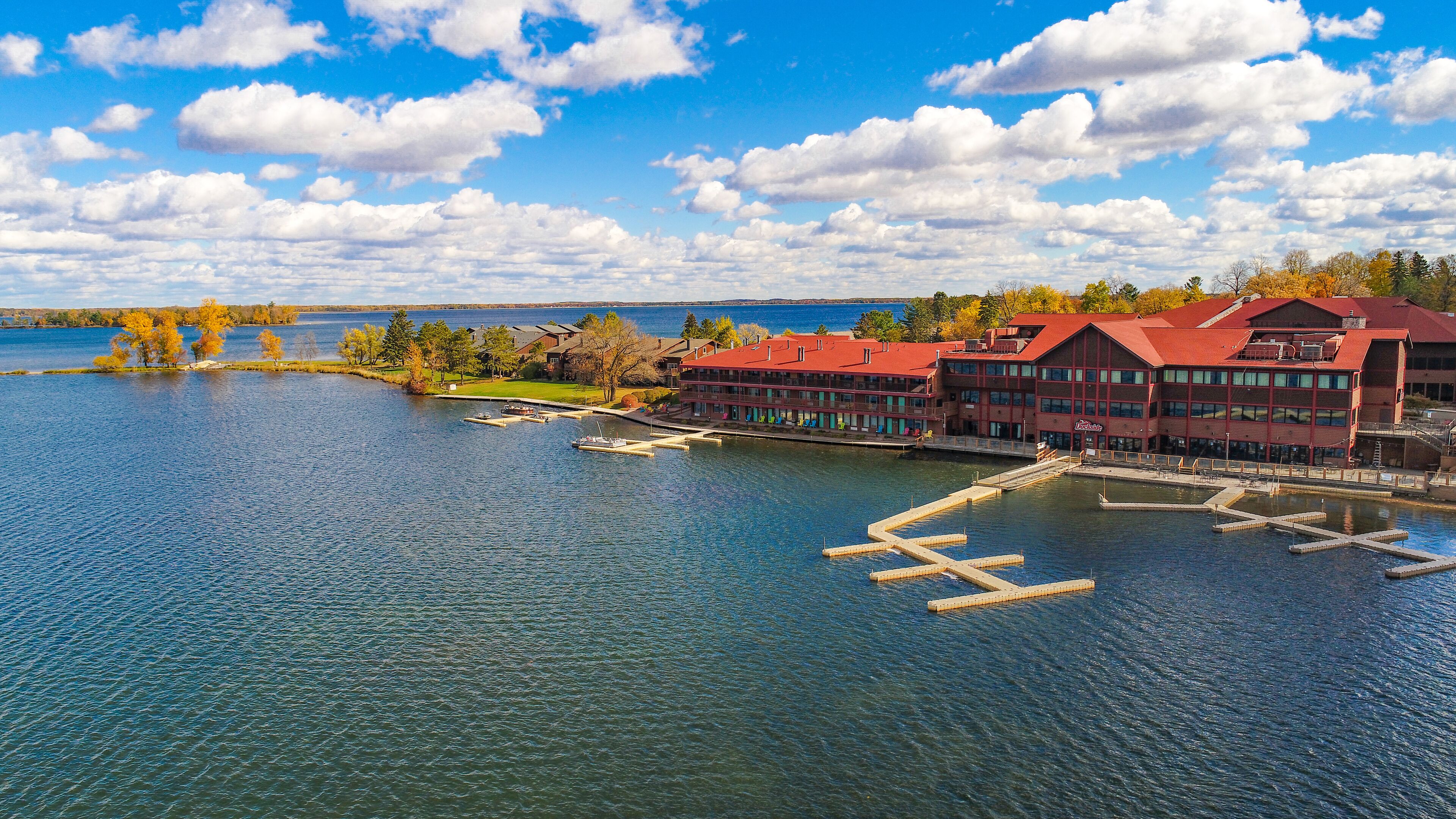 A lakeside building with multiple decks and a dock extending into the water.