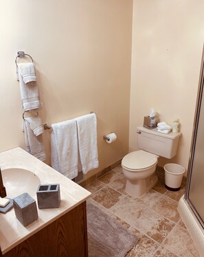 Une salle de bain équipée de toilettes, d’un lavabo et d’un porte-serviettes avec plusieurs serviettes.