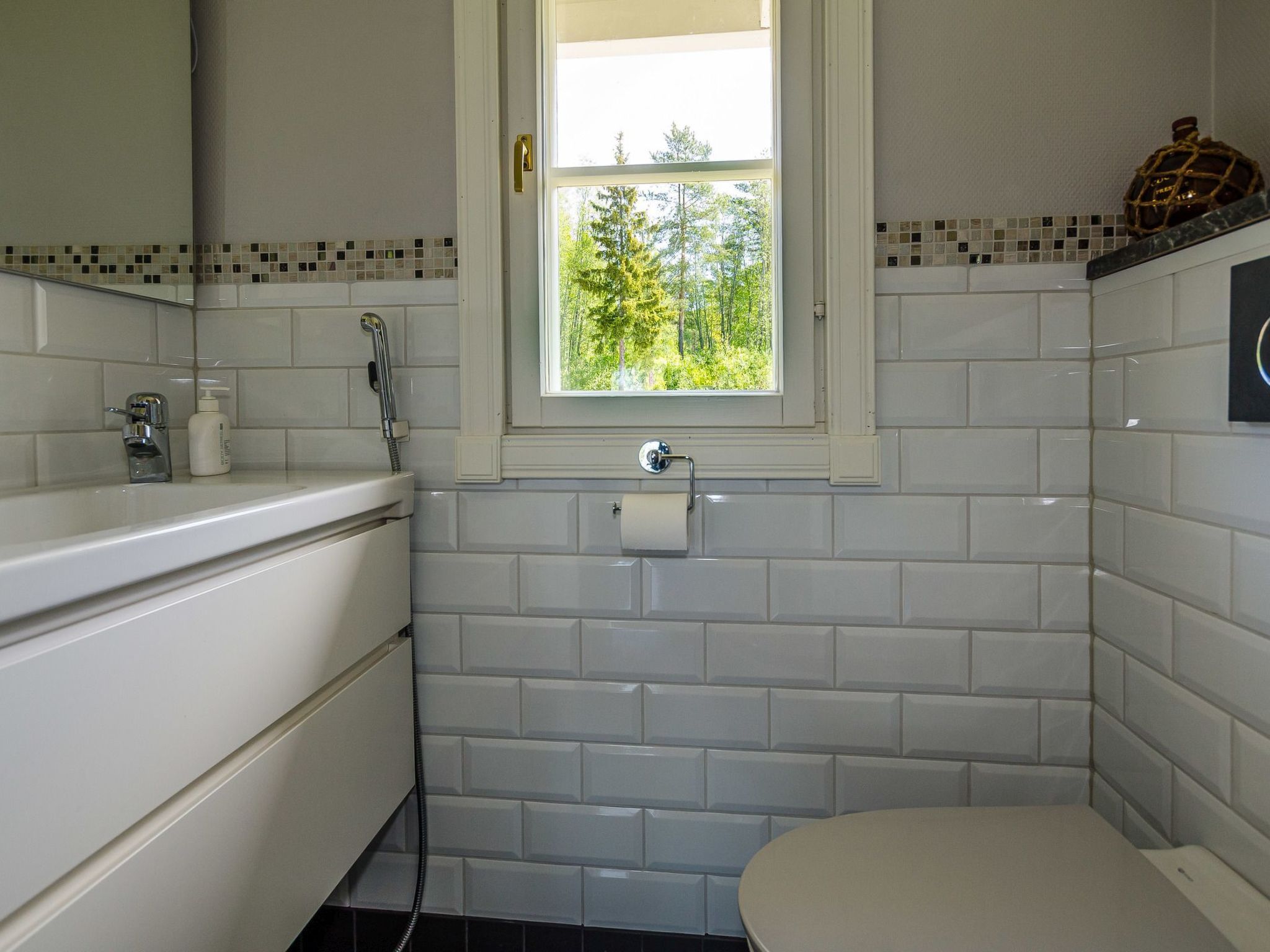 Une salle de bain avec des toilettes, un lavabo et une fenêtre.