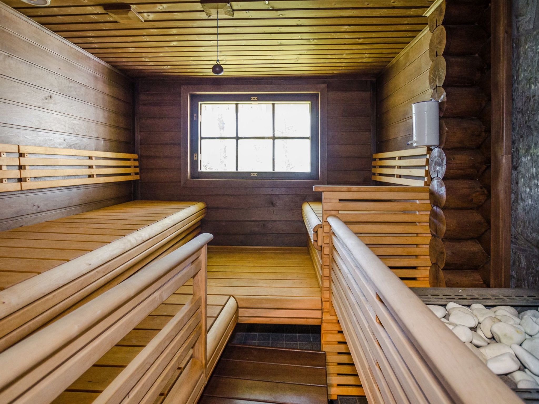 A sauna room with wooden benches and a window.