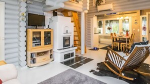 A cozy living room with a fireplace, wooden furniture, and a television.