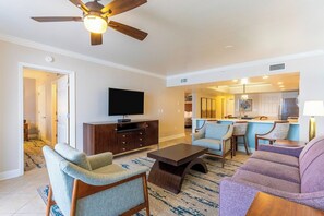 A living room with a TV, wooden entertainment center, and two sofas.