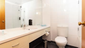 A modern bathroom with a white sink, mirror, and toilet.