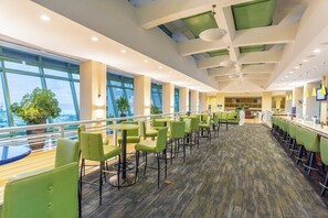 Un espace intérieur vaste et bien aménagé, avec de nombreux coins salon, de grandes fenêtres et une vue sur l’extérieur.
