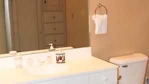 A bathroom with a white vanity, a toilet, a mirror, and a towel rack. - Boyne Mountain, Disciples Village Condo - Steps To Boyneland Run (Boyne falls)