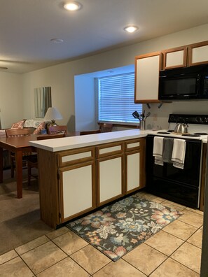 Kitchen area with central island, stove, and dining table.
