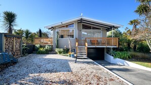 Une maison moderne dotée d’un porche abrité, d’un garage et d’une allée gravillonnée.
