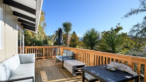 Une terrasse en bois avec un canapé, une table et une chaise.