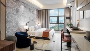 Habitación de hotel moderna con una cama grande, un escritorio y vistas a la ciudad.