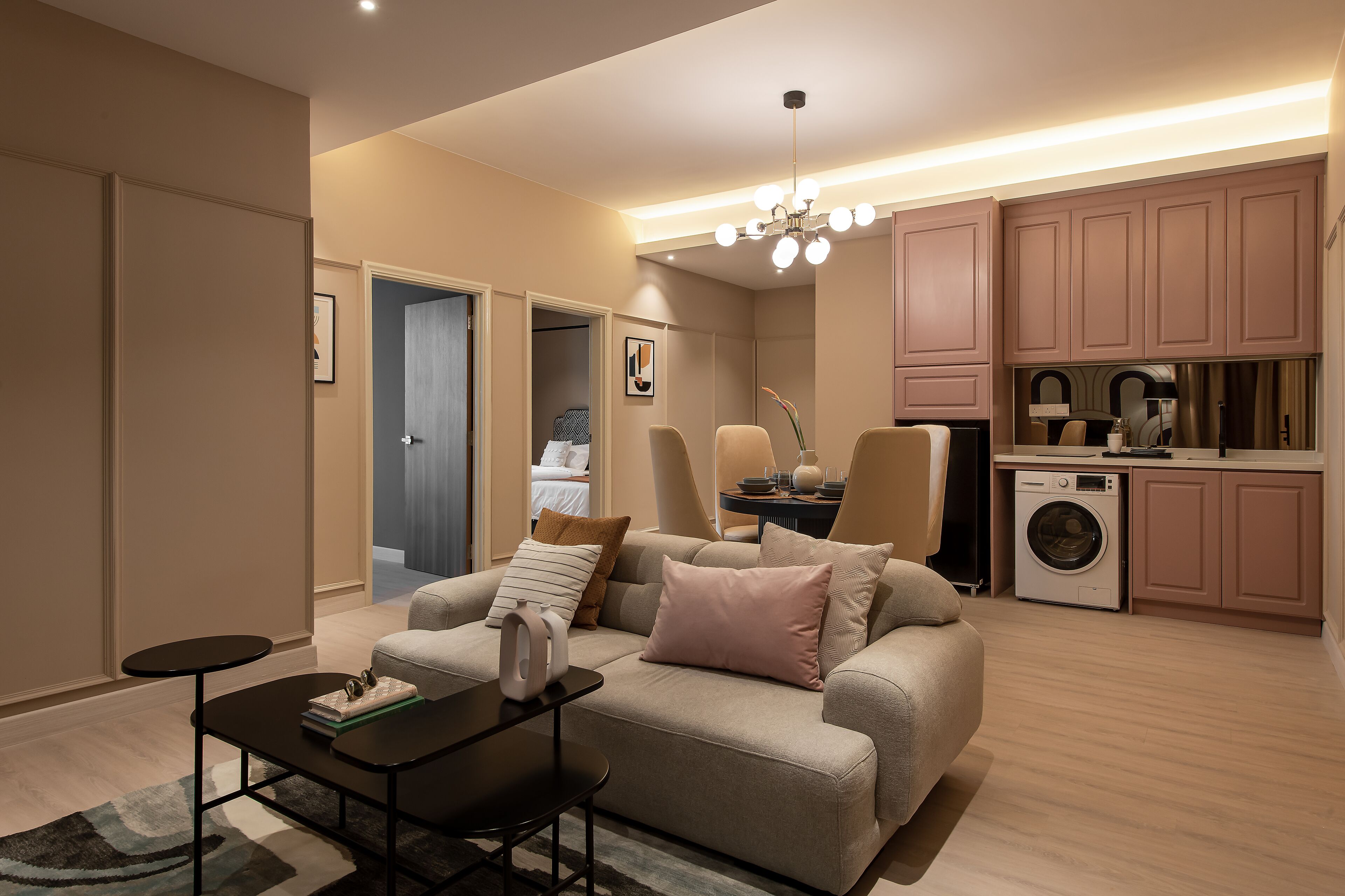 A modern living room with a sofa, coffee table, and a washing machine in the background.
