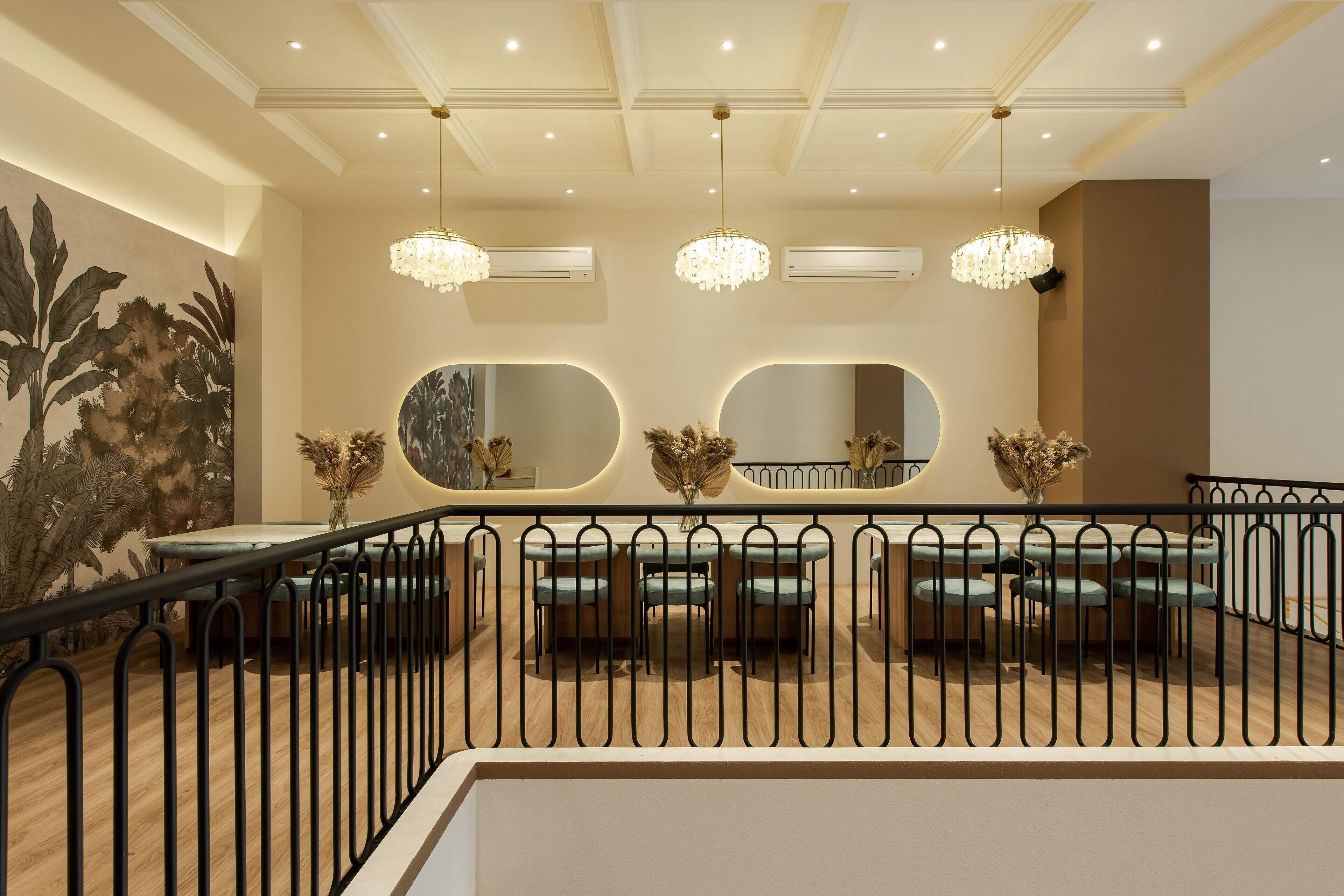 Comedor con techo alto, candelabros y barandilla.
