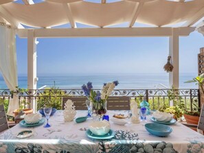 A table set for dining with a view of the sea, white tablecloth, and blue and white dishes. - Terrazza del Sud by Interhome (Menfi)