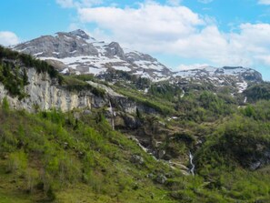 Eine Berglandschaft mit schroffen Klippen und einem Wasserfall.