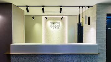 A reception desk with a sign reading "PICO HOTEL" in the background.