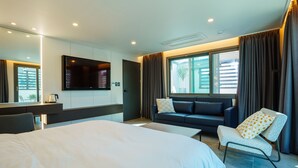 A modern hotel room with a large bed, a sofa, a TV, and a desk. - Hotel Pico (Tongyeong)