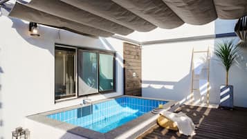 A modern outdoor swimming pool with a blue tiled interior, a wooden deck, and a covered area with a canopy.