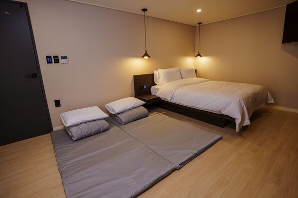 A modern bedroom with a bed, bedside tables, and a control panel on the wall. - Hotel Pico (Tongyeong)