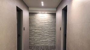 A hallway with a textured wall and a tiled floor. - Hotel Pico (Tongyeong)